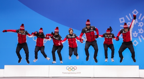 Canada's figure skaters jump atop the podium during the Team Event medal ceremony. (Photo: Greg Kolz)