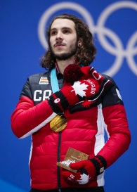 February 18, 2018: Short track speed skater Samuel Girard stands atop the podium during a medal ceremony celebrating his victory in the men's 1000m final. (PHOTO: Greg Kolz)